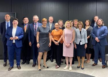 A group of people standing together in front of a black wall